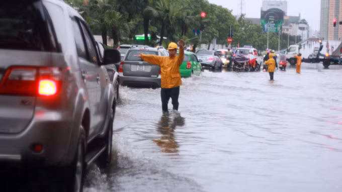 Công nhân Xí nghiệp thoát nước số 1 từ sáng sớm đã phải túc trực tại các điểm nóng về ngập lụt tại Hà Nội để hướng dẫn các phương tiện giao thông tránh các điểm ngập sâu.