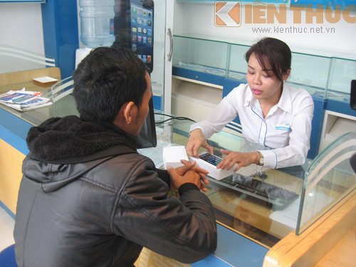 Nhân viên tư vấn bán hàng đang hỗ trợ khách kiểm tra iPhone mới.