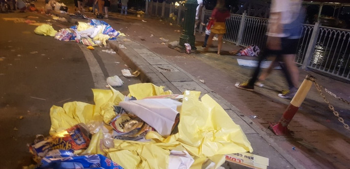 Nơi tập trung hàng chục nghìn người dân đến tham quan đường hoa Nguyễn Huệ và bắn pháo hoa. Sau khi tiệc đón giao thừa và pháo hoa kết thúc, dòng người kéo về để lại rác ngập tràn trên phố. (Ảnh: Tiền Phong).