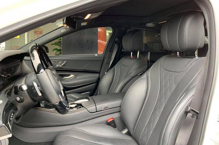 Về hệ thống ghế, Mercedes-Benz S450L Luxury được trang bị ghế lái/ghế hành khách phía trước chỉnh điện, ghế trước nhớ 3 vị trí cũng như ghế sau chỉnh điện đi kèm tựa tay trung tâm ốp gỗ, có ngăn để đồ và khay để cốc. Chưa hết, ghế hành khách phía trước còn có thể tiến sát lên phía trước, tựa đầu gập/tháo rời và tích hợp đỡ chân chỉnh điện sau lưng.