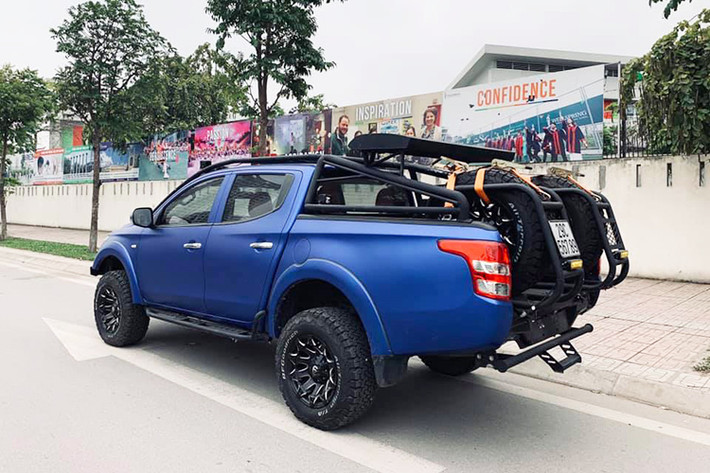 Ngoài ra, chiếc Mitsubishi Triton cũ này còn được trang bị mâm hợp kim thể thao màu đen 17inch, đi kèm lốp xe địa hình và vòm bánh xe mở rộng. Một số chi tiết nhỏ cũng được sơn đen, nhằm tăng diện mạo hầm hố và cá tính, như: thanh chằng đồ trên nóc, hệ thống lốp dự phòng...