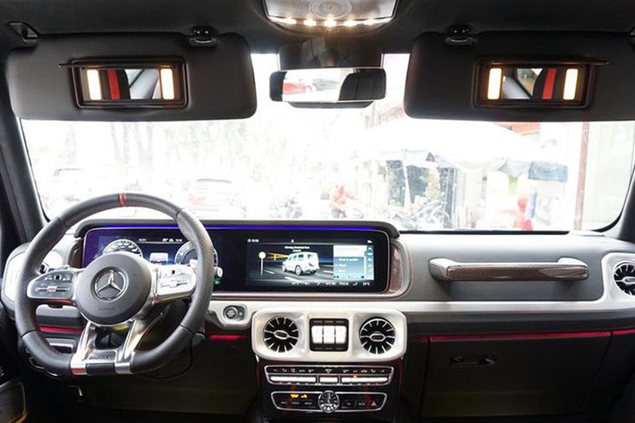 Điểm nhấn bên trong khoang lái của ông vua địa hình Mercedes-AMG G63 Edition 1 đời 2019 mới xuất hiện tại Việt Nam còn có sợi carbon màu đỏ ở bảng điều khiển trung tâm và các chi tiết như dây dai an toàn, viền ở trên đỉnh vô-lăng hay các đường chỉ may màu đỏ.