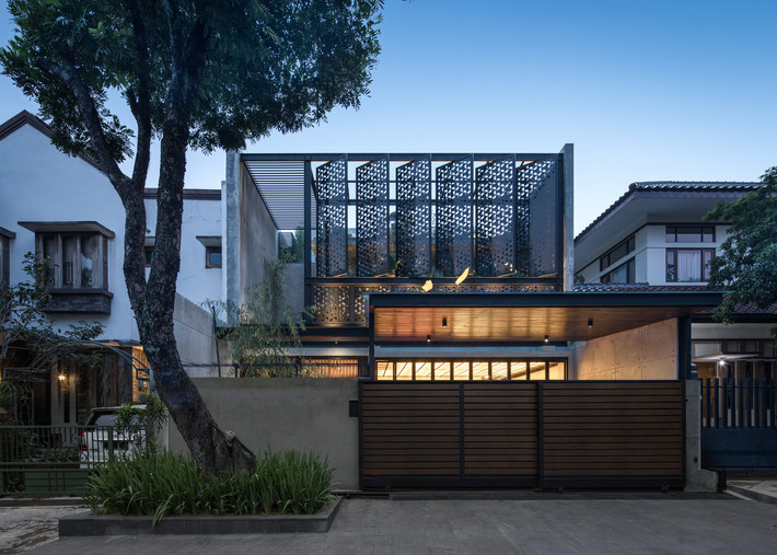 Hệ cổng gỗ đặc khép kín tại tầng 1 và các tấm sắt thông gió lớn tại ban công tầng 2 giúp cho ngôi nhà được bảo vệ bởi ô nhiễm không khí, tiếng ồn, đồng thời đảm bảo không gian bên trong thoáng, sáng.