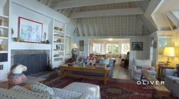 Bên trong căn nhà có phòng khách lớn với trần nhà cao và lò sưởi đốt củi.