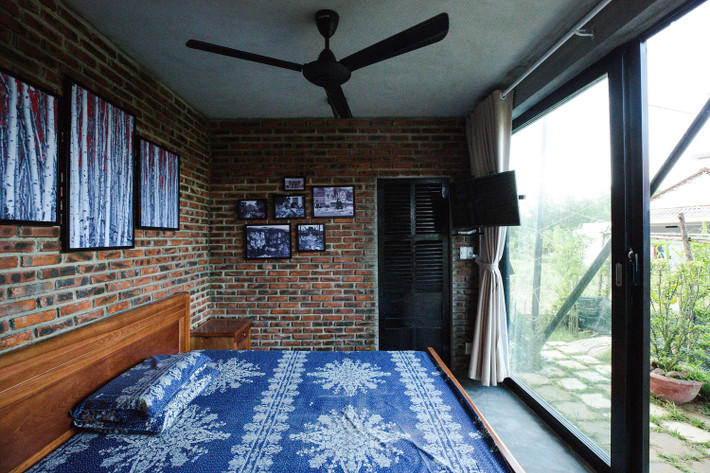 Phòng ngủ thoáng đãng nhìn ra khoảng vườn phía sau ngôi nhà.