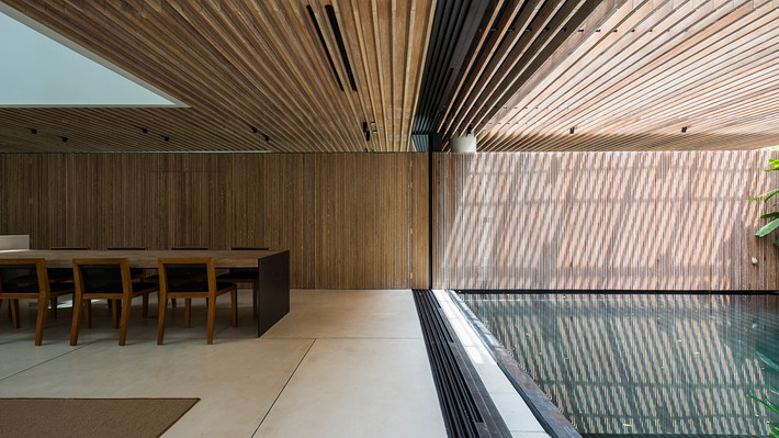 Bàn ăn thiết kế ngay cạnh hồ cá trong nhà. Ảnh: Archdaily