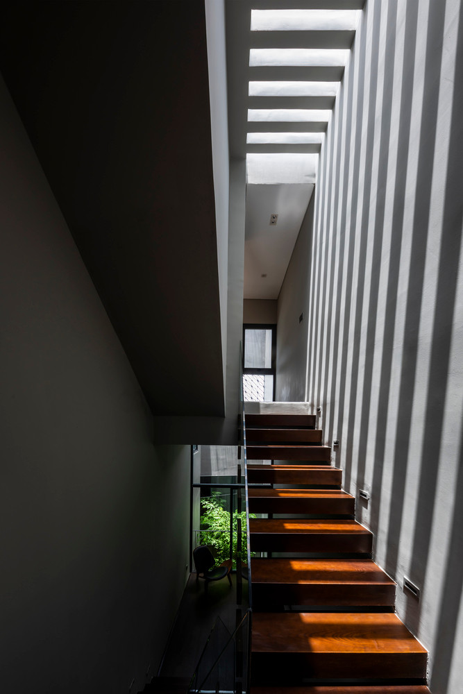 Do đó, giải pháp của các kiến trúc sư là tạo một rãnh sâu chia đôi ngăn cách giữa hai không gian kéo dài xuyên suốt từ tầng trệt lên đến sân thượng nhằm tạo khoảng trống thông gió cùng một lớp tường thứ hai bao bọc phía ngoài nhằm che chắn, giảm bớt bức xạ nhiệt từ bên ngoài trực tiếp vào bên trong công trình theo hướng ngang.