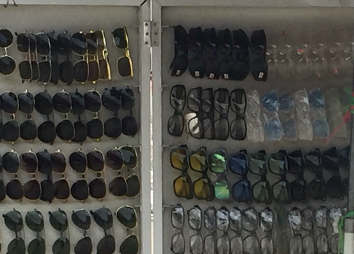 Các loại kính râm có màu sắc, mẫu mã đa dạng dành cho cả nam và nữ được người bán hàng giới thiệu là hàng chất lượng tốt, dùng bền, đeo vào êm mắt... (Ảnh: Hồng Anh)