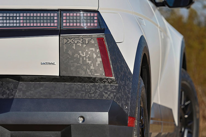 Chiếc xe SUV điện IONIQ 5 XRT cũng có nhiều điểm nhấn màu đen, từ viền cửa sổ và ốp gương cho đến huy hiệu trên khắp ngoại thất. Bánh xe 18 inch chuyên dụng cũng được sơn màu đen mờ và cũng hiển thị cùng chủ đề pixel Ioniq trên bề mặt của nó.