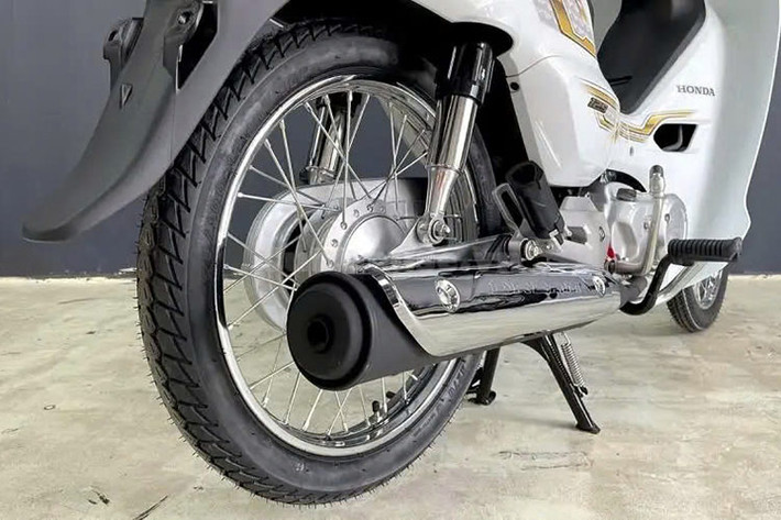 Honda Dream 125 2025 dùng phanh tang trống, phần ống xả có thêm ốp bảo vệ mạ chrome. Bên dưới yên xe có hộc chứa đồ, mở bằng chìa khóa cơ. Hệ thống treo kép đem lại hành trình thoải mái hơn. 