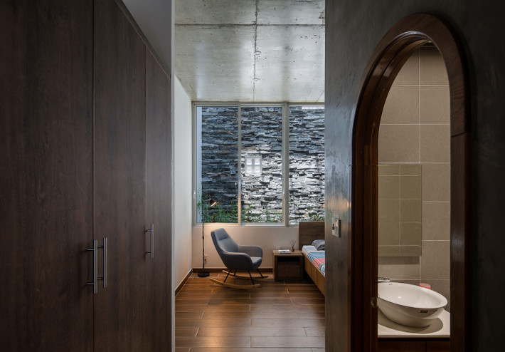 Phòng ngủ bị đẩy xuống cuối nhà nhưng vẫn thoáng đãng nhờ khoảng thông tầng. Ảnh: Quang Tran