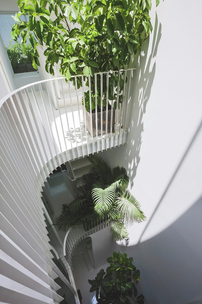 Ban công, tường và cửa ra vào đều có góc tròn để phù hợp với khoảng thông tầng hình chữ D. Ảnh: Hiroyuki Ok