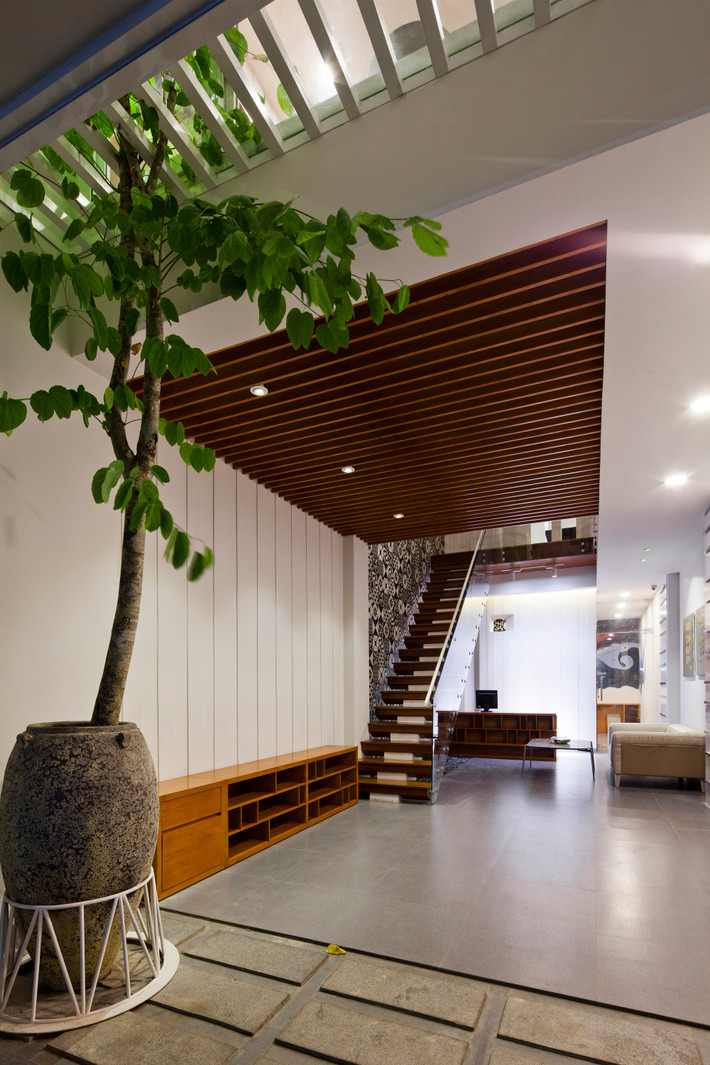 Ánh sáng cũng đi từ trên xuống qua giếng trời ở giữa nhà, ánh sáng này được lọc qua các tấm thạch cao nằm ngang bên dưới mái kính. Ảnh: Hiroyuki Oki