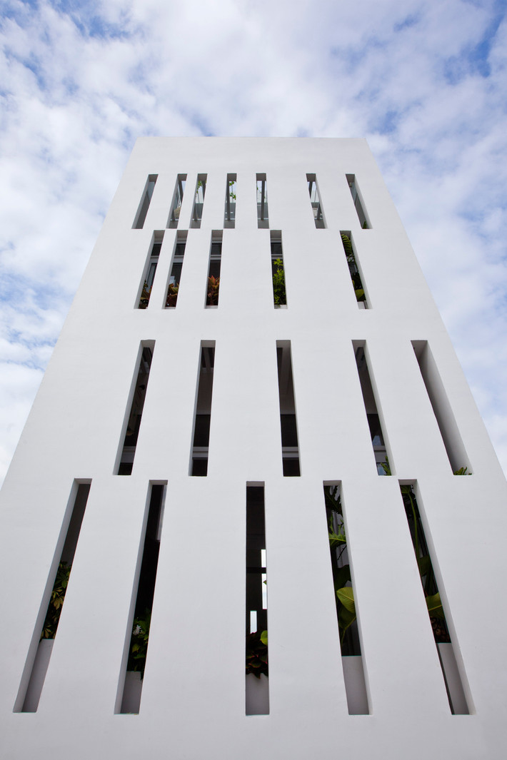 Giải pháp đưa ra là xây bức tường thiết kế những khe thông thoáng với chiều rộng 13cm để sử dụng làm vỏ bao bọc và ngăn chia không gian theo nhu cầu sử dụng của các thành viên trong nhà. Ảnh: Hiroyuki Oki