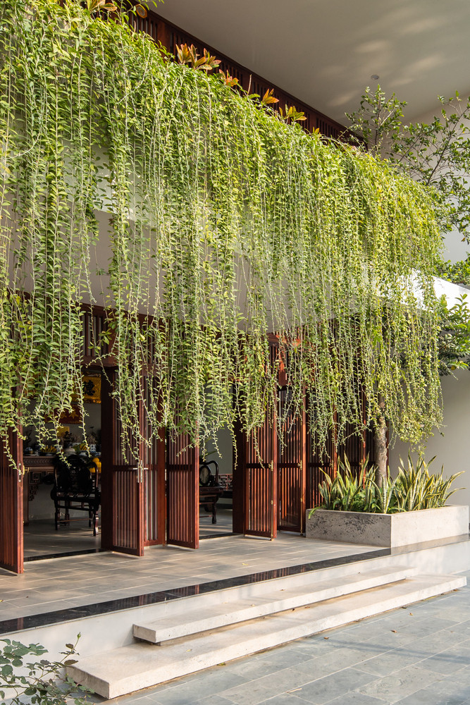 Phần hiên được lùi vào một khoảng, sử dụng rèm cây vừa để lọc không khí đi vào nhà vừa giảm tác động ánh nắng mặt trời.