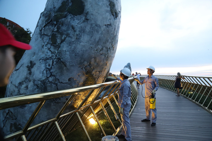 Tròn một ngày sau khi Cầu Vàng Đà Nẵng bị vẽ bậy, các công nhân của khu vực này đã nhanh chóng dùng sơn màu xám để che đi dòng chữ xấu xí kia.