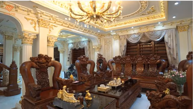 Nổi bật nhất là bộ bàn ghế bằng gỗ hương đỏ Gia Lai với đường nét trạm trổ hoa văn công phu trong phòng khách.