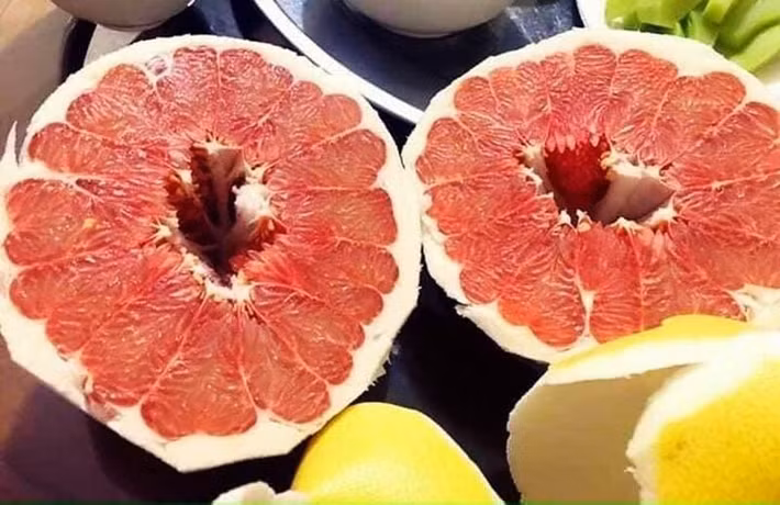 Vài tuần gần đây, bưởi được bày bán nhiều tại các khu chợ ở Hà Nội và "chợ mạng". Bên cạnh các loại bưởi trong nước như bưởi Phúc Trạch, bưởi Tân Lạc, bưởi Năm Roi, bưởi Hoàng… trên thị trường những ngày này còn xuất hiện loại bưởi có vỏ vàng óng vô cùng bắt mắt, phần ruột đỏ au. Ảnh: Vietnamnet.