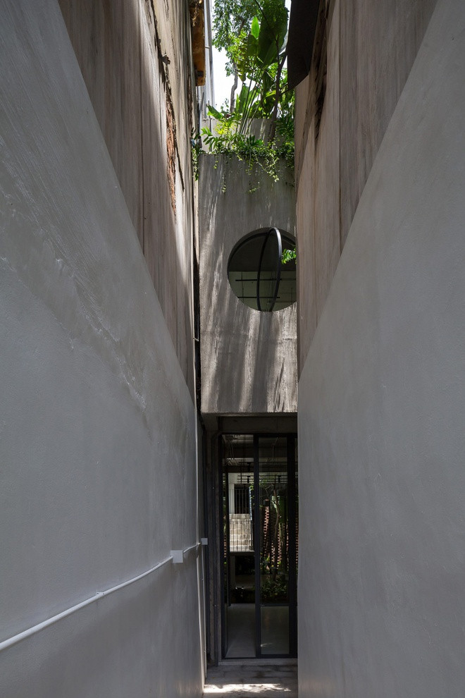 Hai tầng dưới của nhà ống 6 tầng được sử dụng với mục đích kinh doanh. Vì vậy, kiến trúc sư thiết kế một ngõ nhỏ riêng cho gia chủ khi không muốn đi qua cửa chính.