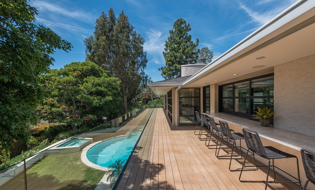 Không gian thư giãn ngoài trời gồm có khu vực ăn uống, hồ bơi, và bồn tắm nước nóng. Khu vườn đầy cây cao đảm bảo tính riêng tư cho gia chủ.