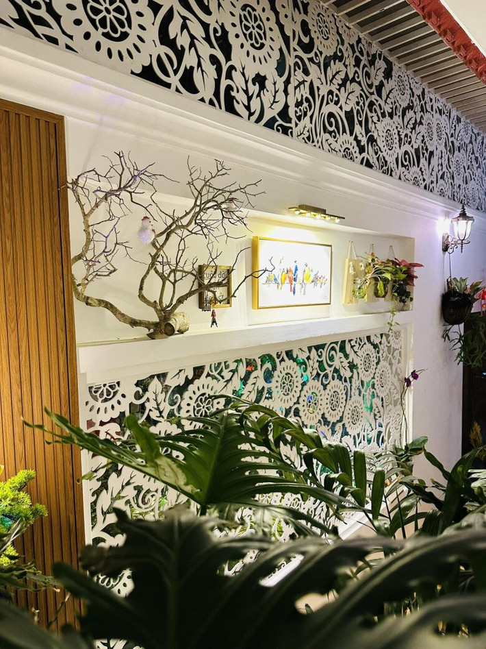Bên trong nhà được trang trí với nhiều họa tiết hoa văn đục lỗ kết hợp cây cảnh. Ảnh: FBNV
