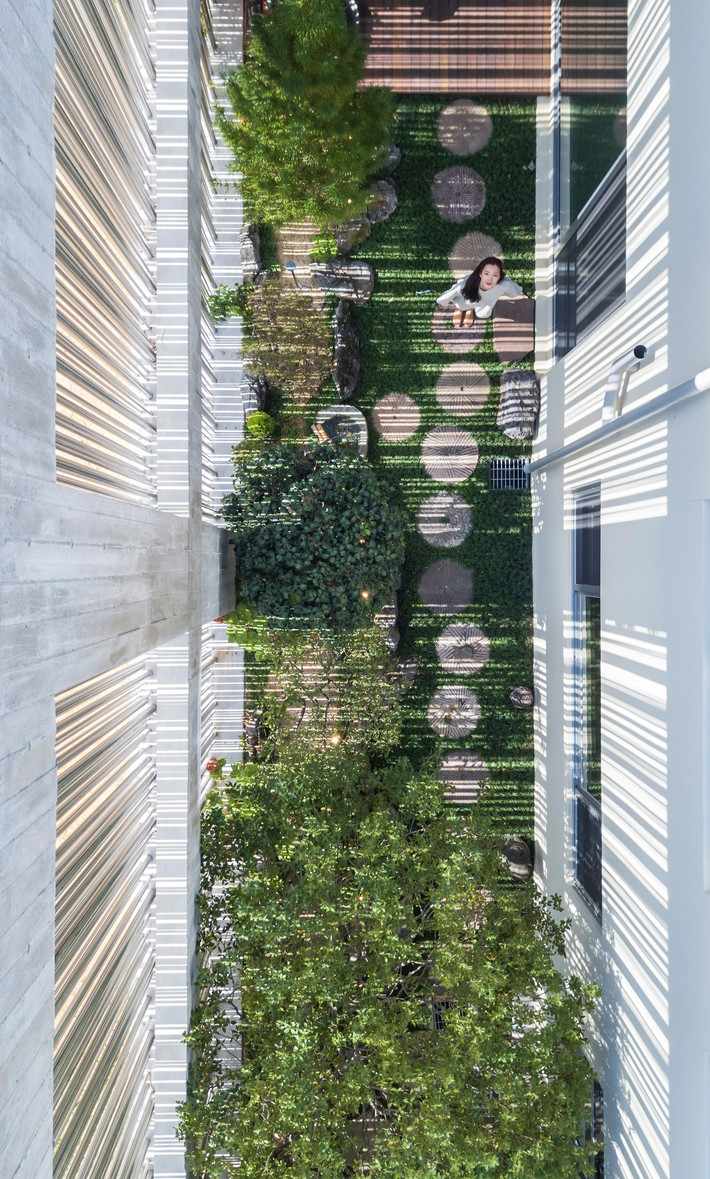 Ngay sau mặt tiền ống thép là khoảng sân vườn xanh mướt mắt.