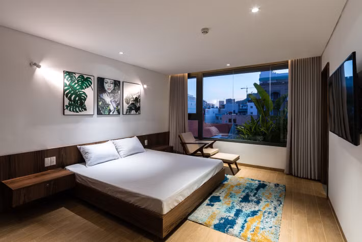 Phòng ngủ với cửa kính lớn giúp nhìn toàn cảnh thành phố từ trên cao.