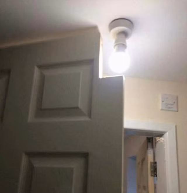 Chiếc đèn này chắc được treo trước khi lắp cửa.