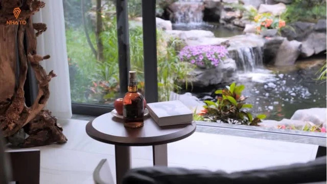 Phòng khách không chỉ rộng mà còn thoáng đãng nhờ hệ thống cửa kính đón ánh sáng được thiết kế theo dạng cửa trượt, lưu thông không khí với khu vực sân vườn bên ngoài. Ảnh chụp màn hình