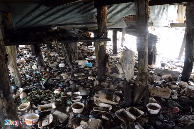 Những tấm sàn ván gỗ được chống đỡ bởi các cọc cây gỗ nhỏ cắm xuống dòng sông. Tồn tại lâu năm, ngâm nước phơi nắng thường xuyên nên nhiều cọc đã mục nát, nguy cơ đổ sập rất cao. Phía dưới sàn nhà rác nổi lềnh bềnh, bốc mùi hôi thối.