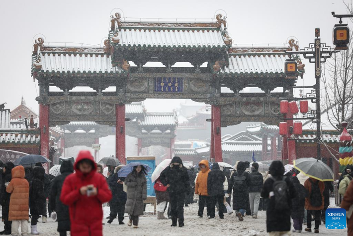 Mọi người đi bộ dưới trời mưa tuyết bên ngoài Cố cung Thẩm Dương.