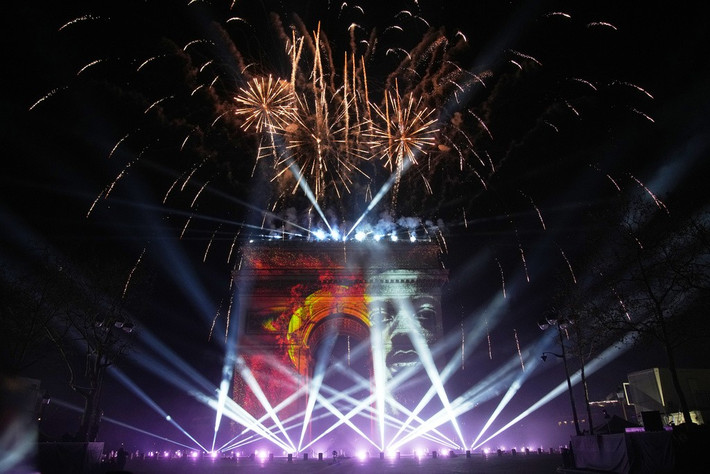 Màn trình diễn ánh sáng ở Khải Hoàn Môn cùng lúc pháo hoa rực rỡ trong lễ đón năm mới trên đại lộ Champs Elysees ở Paris, Pháp. Ảnh: AP.