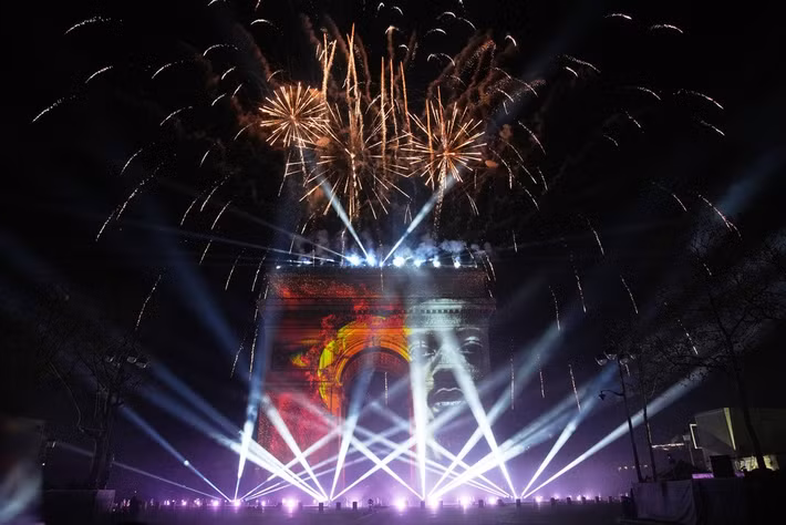 Màn trình diễn ánh sáng ở Khải Hoàn Môn cùng lúc pháo hoa rực rỡ trong lễ đón năm mới trên đại lộ Champs Elysees ở Paris, Pháp. Ảnh: AP.
