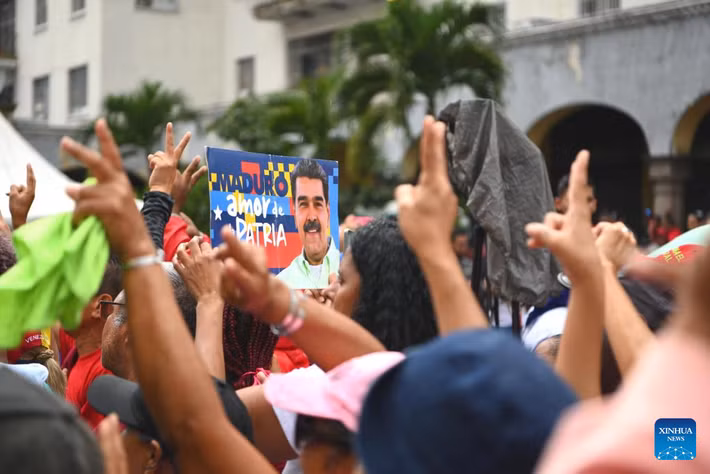 Những người tham gia cuộc biểu tình ở thủ đô Caracas ngày 7/1 mang theo ảnh của Tổng thống Maduro.