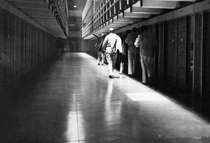 Các tù nhân đi qua một dãy phòng giam có lính canh giám sát. Ảnh: Cục Công viên Quốc gia.