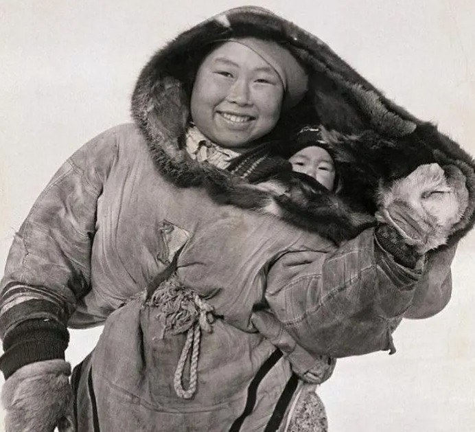 Một phụ nữ Inuit bế con trong bộ quần áo giữ ấm mùa đông năm 1940.