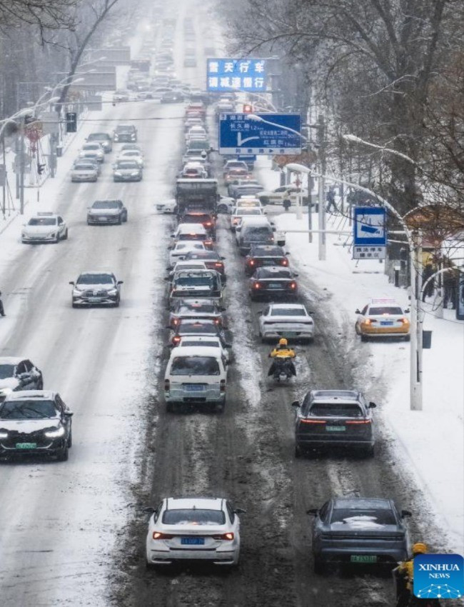 Những chiếc xe lưu thông trên đường phố ở Trường Xuân, tỉnh Cát Lâm, trong một ngày tuyết rơi vào mùa đông.