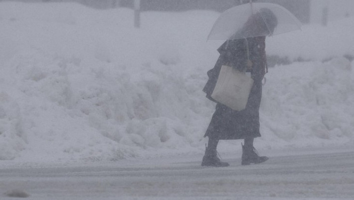 Tại cuộc họp hôm 3/2, Thủ tướng Nhật Bản Sanae Takaichi kêu gọi người dân hãy theo dõi sát sao thông tin thời tiết và thực hiện các biện pháp để đảm bảo an toàn cho bản thân. Ảnh: Một người đi bộ dưới trời mưa tuyết ở Nagaoka, tỉnh Niigata, ngày 22/1/2026. Ảnh: Kyodo.