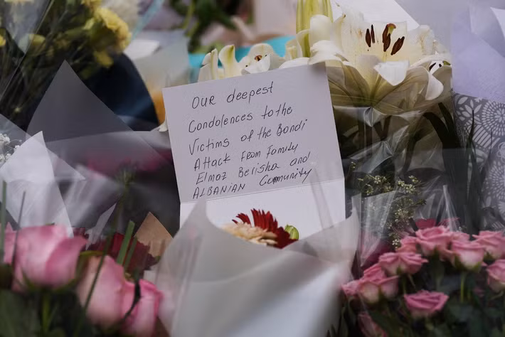 Lời chia buồn gửi tới nạn nhân vụ xả súng được đặt cùng những bông hoa trong buổi lễ tưởng niệm ngày 15/12. Ảnh: AP.