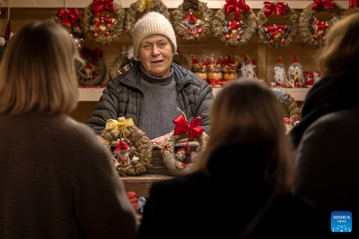 Một người bán hàng giới thiệu sản phẩm cho khách tham quan tại một gian hàng thủ công mỹ nghệ ở chợ Giáng sinh Helsinki ngày 5/12/2025.