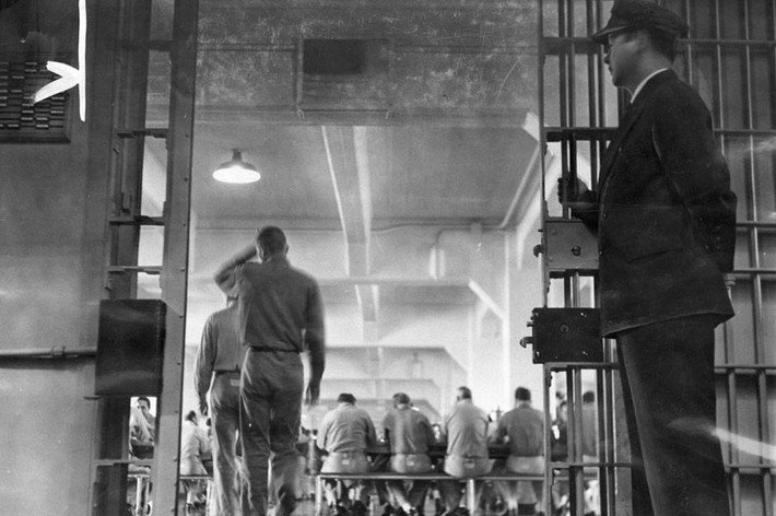 Một người lính canh đứng gác khi tù nhân vào nhà ăn trong tù năm 1962. Ảnh: Cục Công viên Quốc gia.