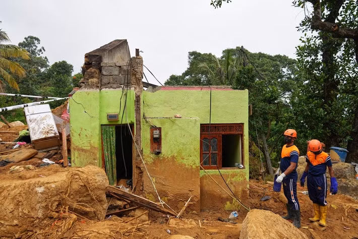 Ông Sundaralingam Pradeep, Thứ trưởng Bộ Nông nghiệp và Cơ sở hạ tầng cộng đồng của Sri Lanka, cho biết Chính phủ đang đàm phán với các công ty chè để xác định các khu đất xây nhà cho tất cả những người bị ảnh hưởng bởi thảm họa. Ảnh: Các binh sĩ Sri Lanka đứng cạnh dãy nhà ở của công nhân đồn điền chè bị phá hủy sau vụ sạt lở đất do bão Ditwah gây ra tại đồn điền Craighead ở Nawalapitiya, Sri Lanka, ngày 11/12.