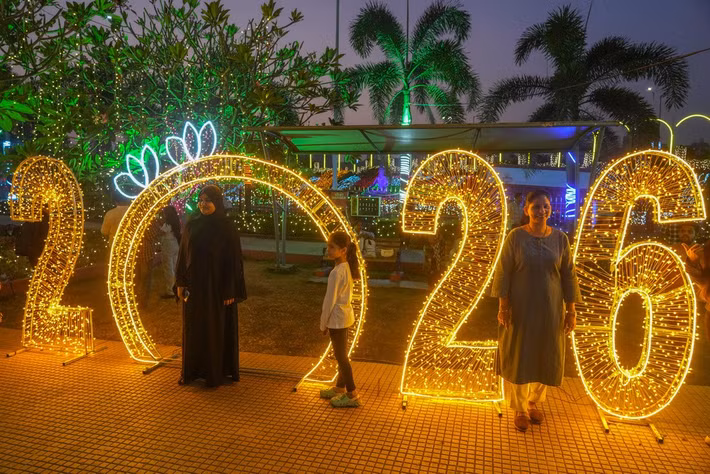 Mọi người tạo dáng chụp ảnh trong đêm Giao thừa ở Mumbai, Ấn Độ, ngày 31/12/2025. Ảnh: AP.