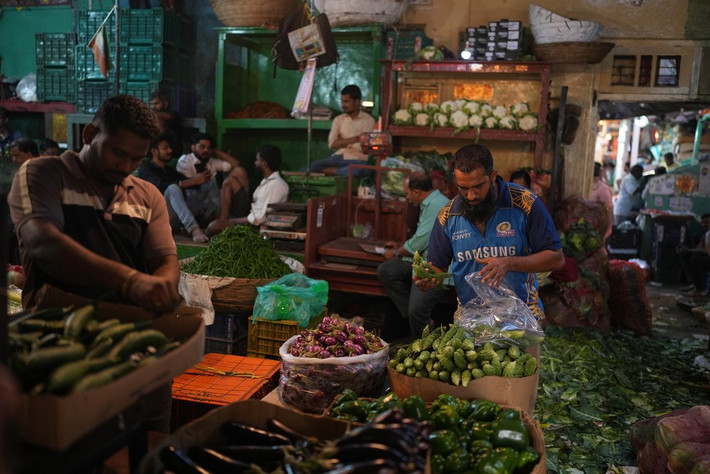 Người đàn ông mua rau củ tại một khu chợ địa phương ở Mumbai ngày 1/2.