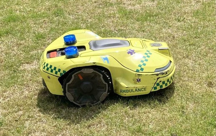 Máy cắt cỏ robot tại bệnh viện có hình dáng là một chiếc xe cứu thương nhỏ.