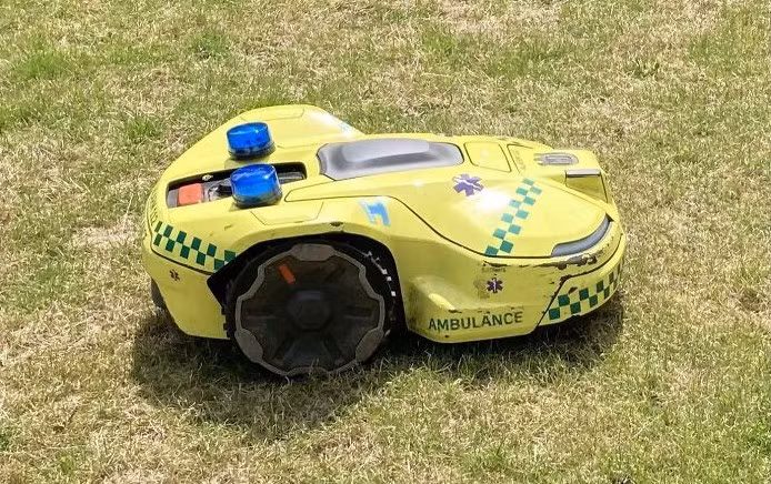 Máy cắt cỏ robot tại bệnh viện có hình dáng là một chiếc xe cứu thương nhỏ.