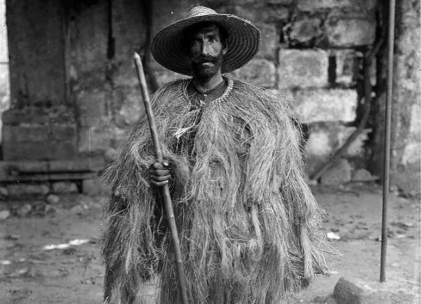 Được chụp vào khoảng năm 1900 bởi Auguste Bobone, bức ảnh này cho thấy một người chăn cừu Bồ Đào Nha mặc áo choàng rơm truyền thống và cầm một cây gậy.