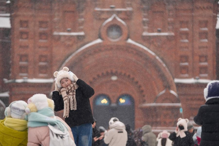 Cô gái chụp ảnh lưu niệm tại một quảng trường ở Cáp Nhĩ Tân ngày 23/12/2025. Ảnh: Xinhua.