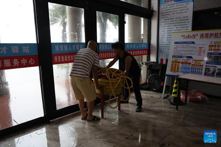 Người dân chặn cửa khi gió mạnh tại một cảng cá ở thành phố Mậu Danh ngày 5/10. Ảnh: THX.