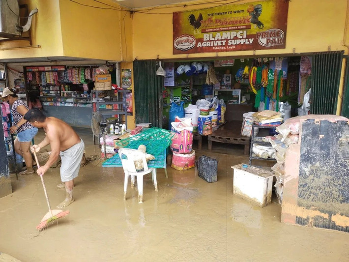 Người dân ở Tabango, Leyte, dọn dẹp bùn đất sau khi bão Bualoi đổ bộ vào khu vực này.